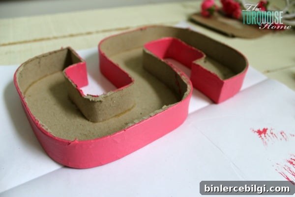 Cut the top off of a simple paper mache initial from Hobby Lobby and fill it with moss and flowers for a sweet addition to a baby girl's nursery. | DIY Flower and Moss Initial Art via TheTurquoiseHome.com