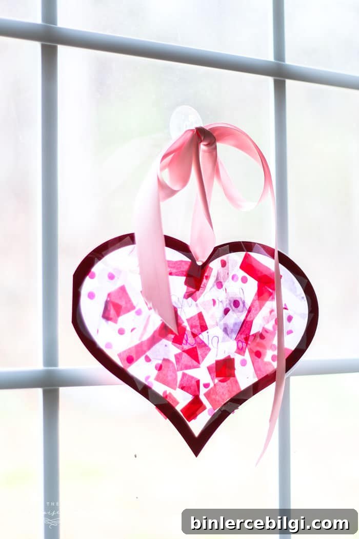 We used this in my daughter's Kindergarten class party! The kids LOVED it! | DIY Tissue Paper Sun Catcher Valentine's Kid Craft
