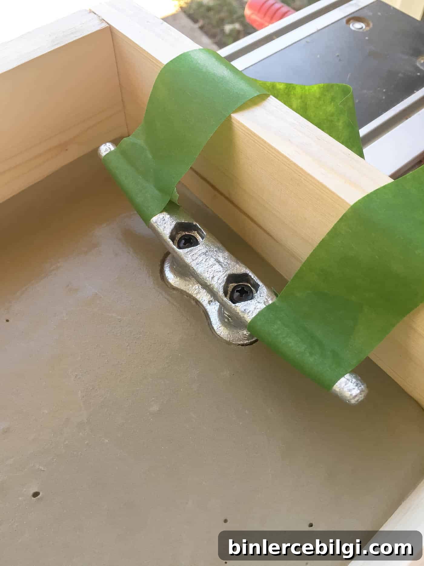 Dock cleat handles in concrete tray held up by painter's tape.