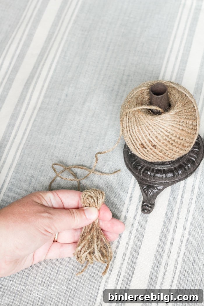 Pinching and tying the tassel to secure the top.