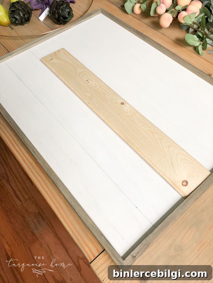 Draw "shiplap" lines on the framed board with a pencil and a scrap piece of wood!