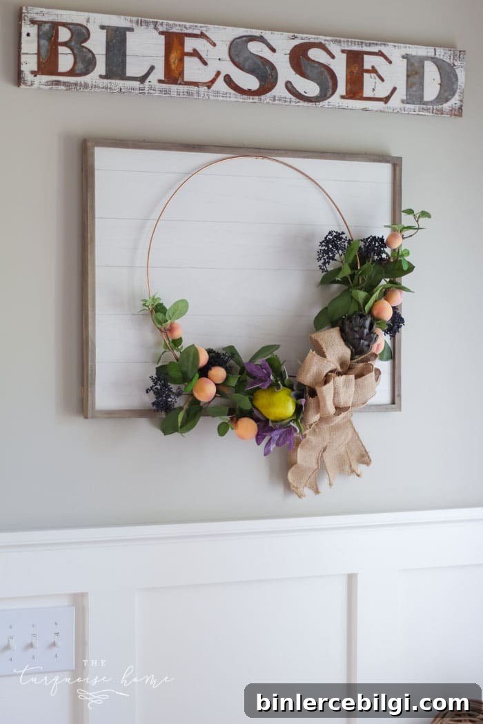 Gorgeous fall wreath with fruit on a "shiplap" framed backdrop.