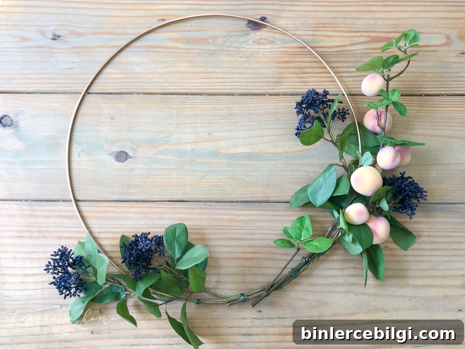 Attach the floral and fruit stems to the wreath hoop.