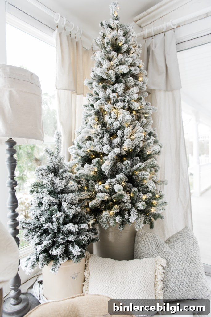 Two simple flocked Christmas trees displayed in crocks