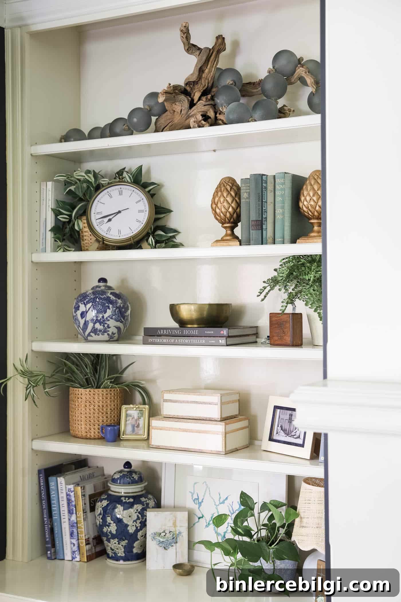 layering art and decorative objects on a bookshelf.