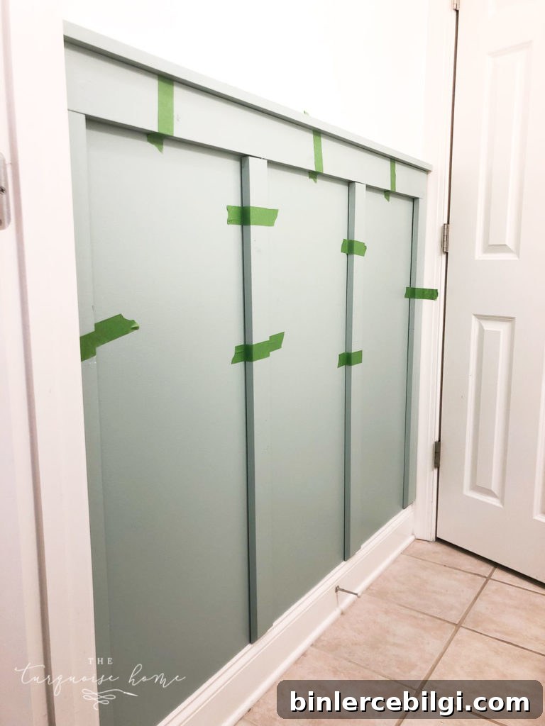DIY Board and Batten Tutorial - place boards in the wall and hold them up with painter's tape to see where they should go!