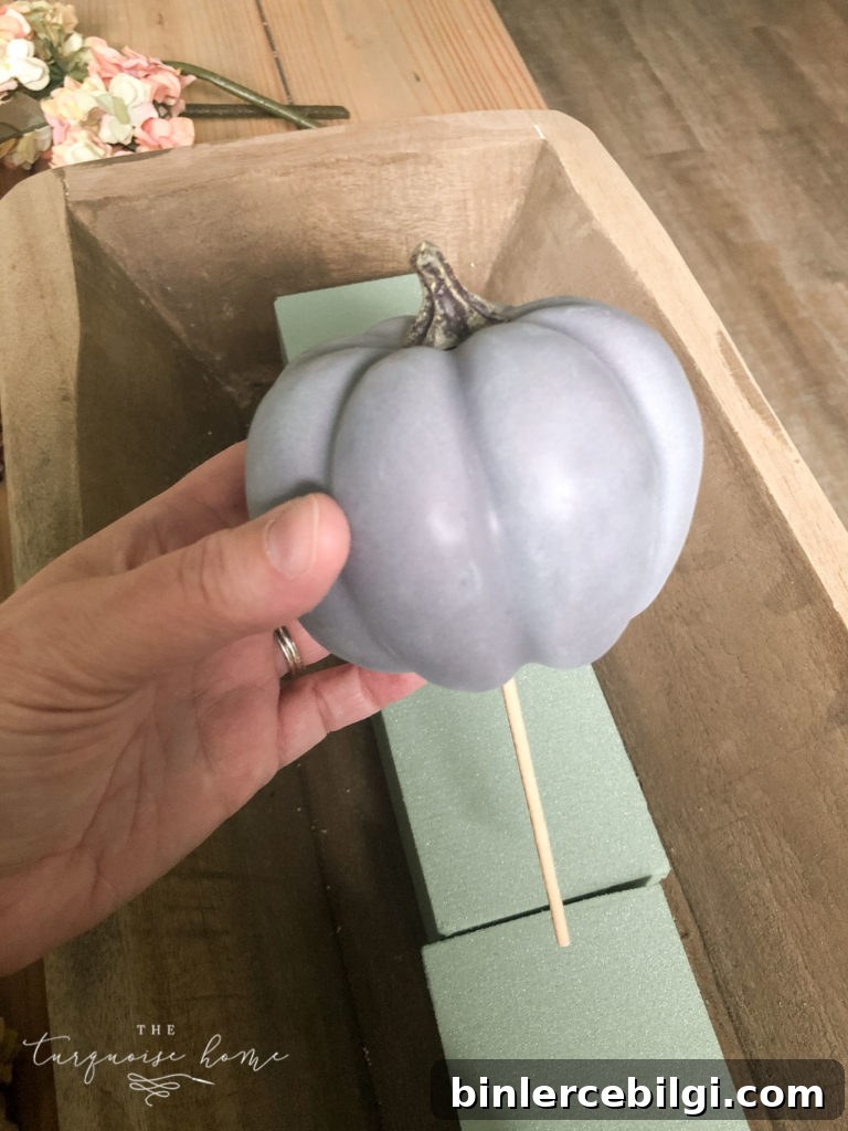 Use a skewer to add the pumpkins to the floral foam