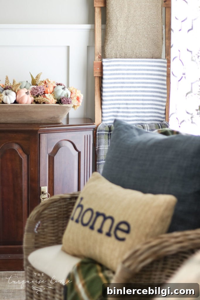 Fall pumpkin centerpiece with home pillow and blanket ladder.