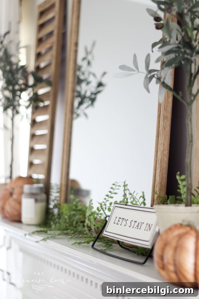 Shutter and olive tree with 'let's stay home' sign and a wood grain pumpkin.