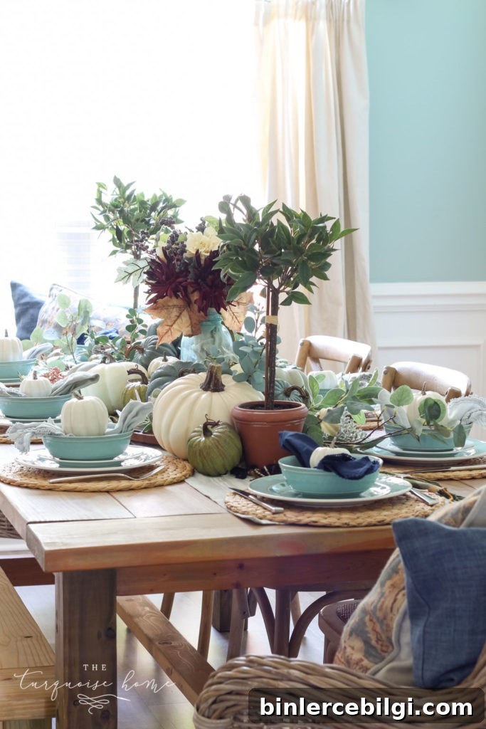 Pumpkins and Greenery Fall Tablescape with bay leaves in a pot and fall floral arrangement.