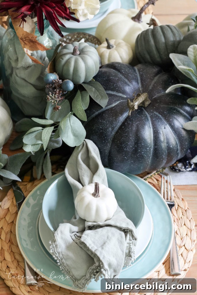 Pumpkins and Greenery Fall Tablescape with bay leaves in a pot and fall floral arrangement.