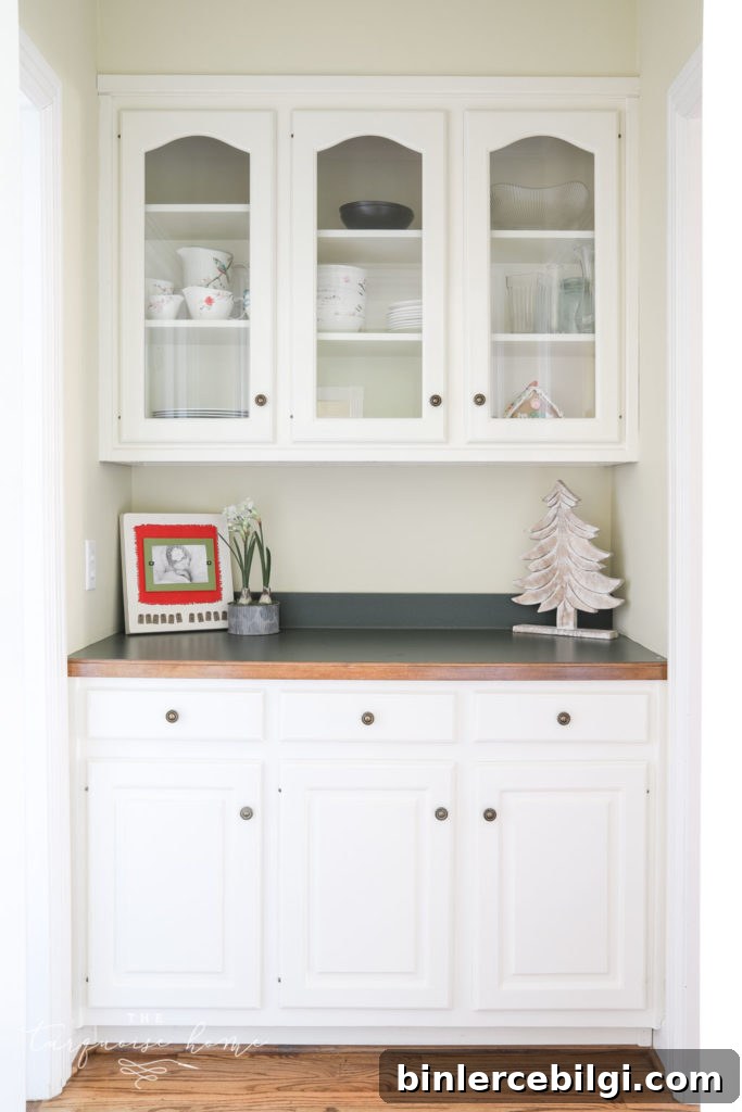 Butler's pantry with glass-front cabinets and hunter green countertops. 