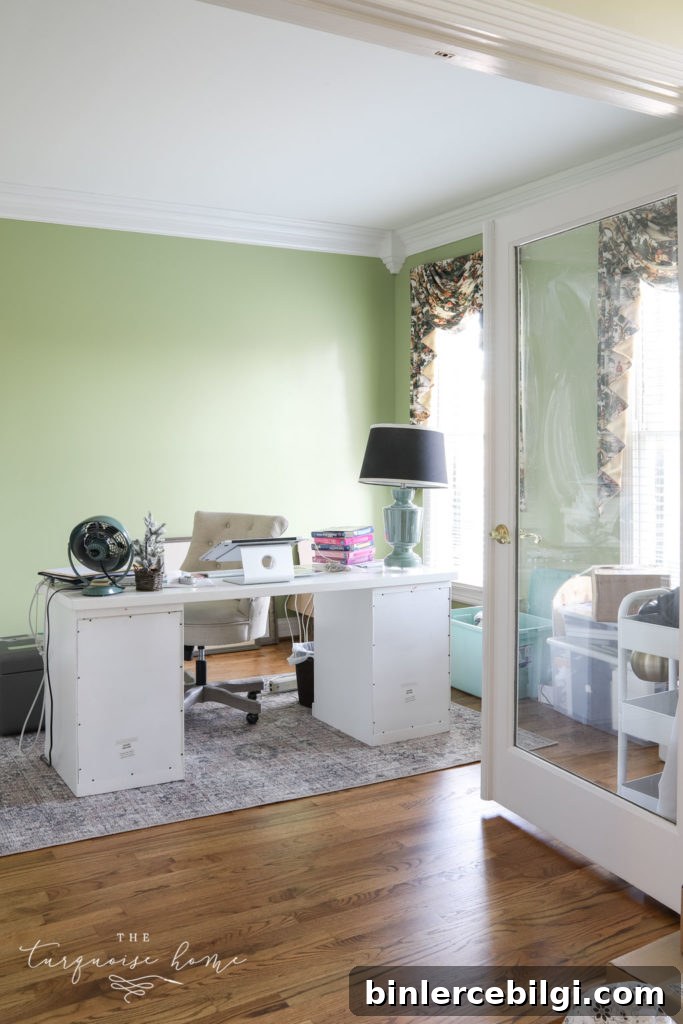 Feminine office with lime green walls and desk in the middle of the room.