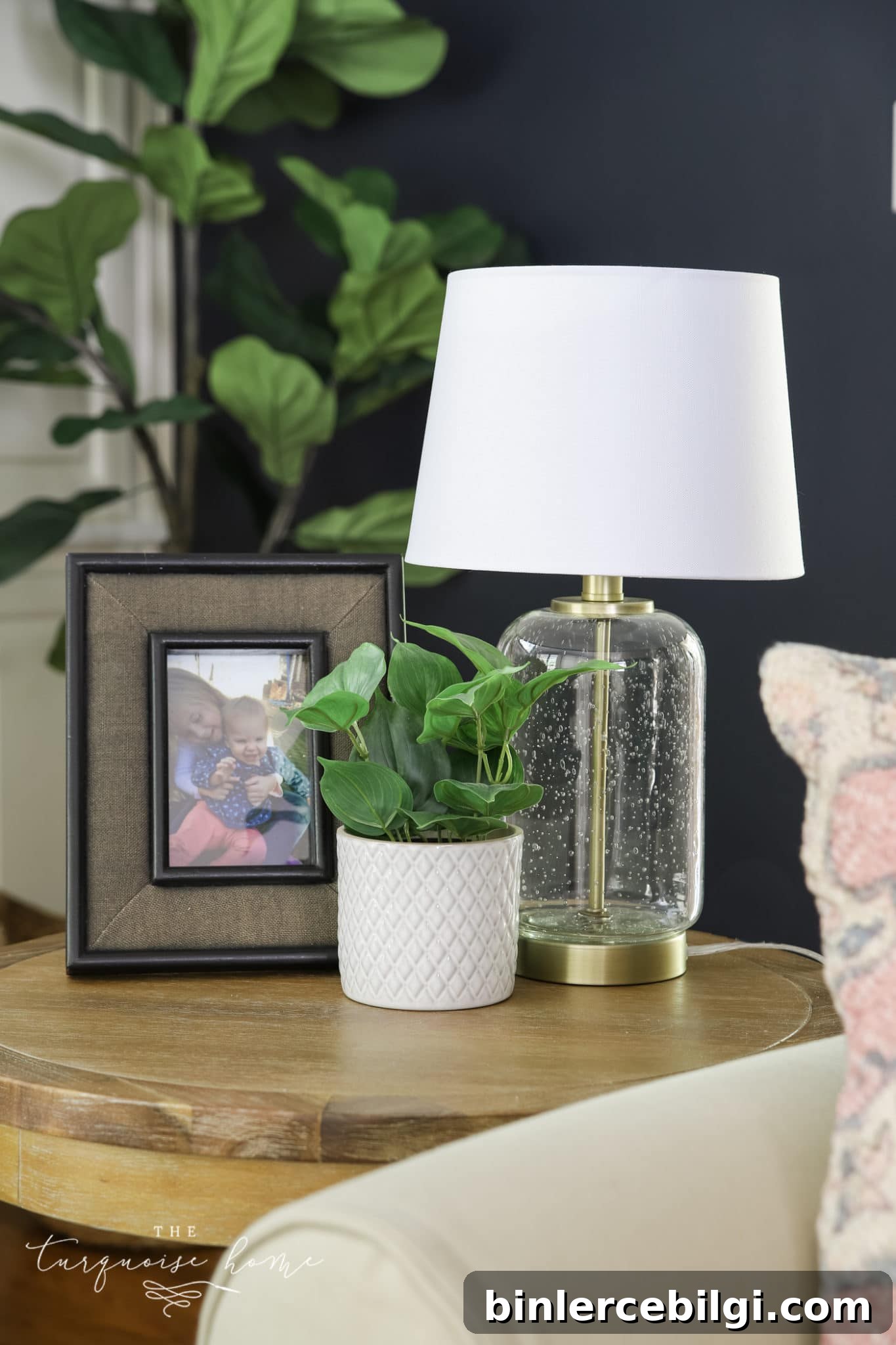 end table with lamp, frame and greenery