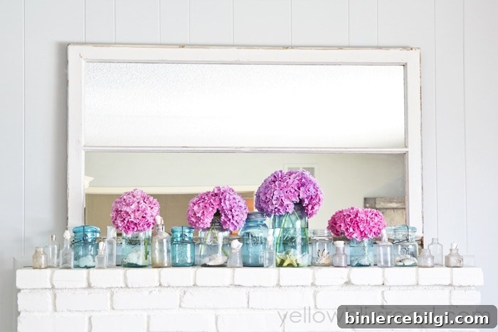 bright pink blooms and blue jars in front of a mirror on a mantel