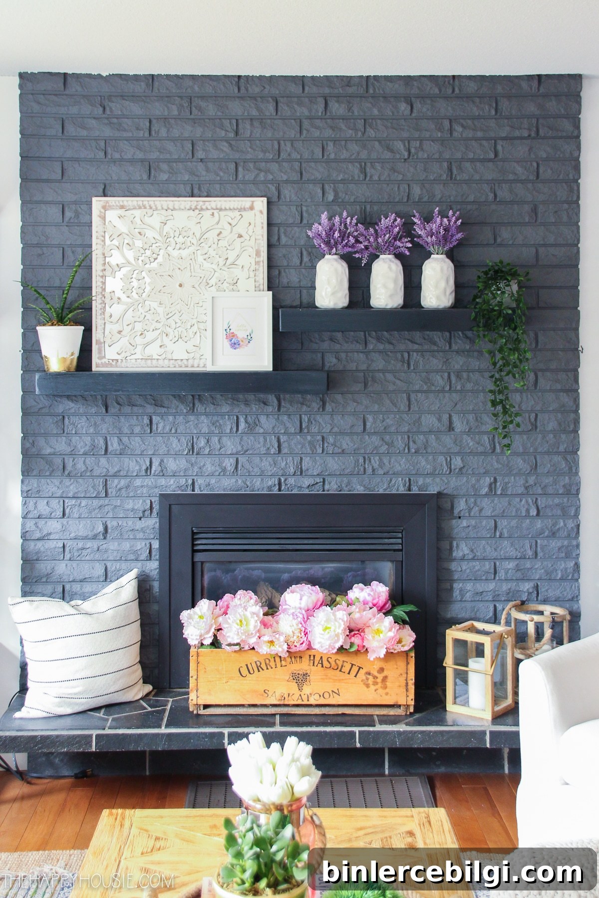 dark gray brick fireplace with spring flower blooms on mantel