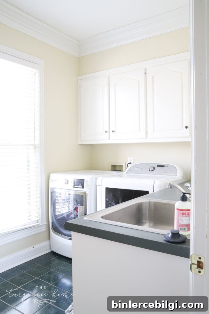 Laundry room with lots of storage, hunter green tiles on the floor and hunter green countertops.