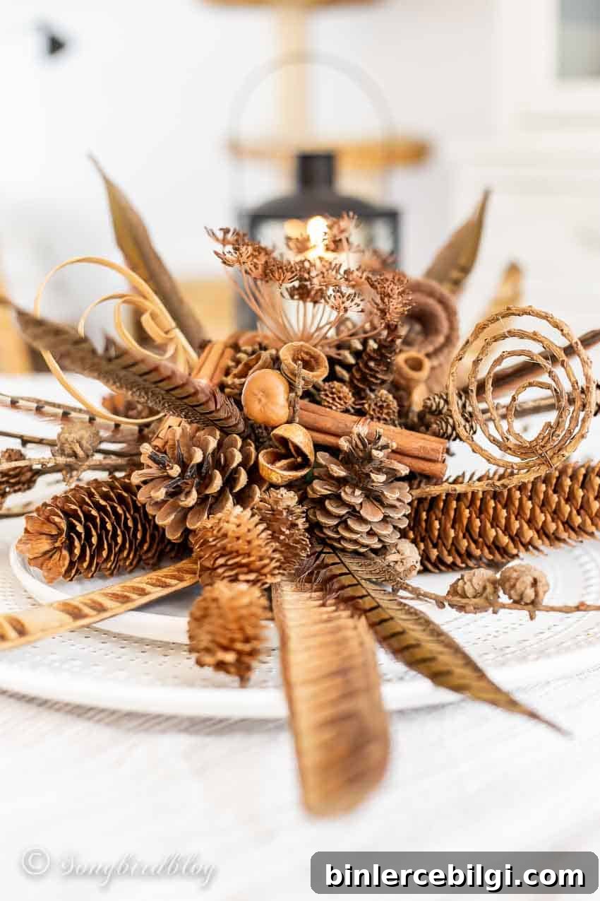 pinecones, cinnamon sticks, feathers, and florals in a fall centerpiece