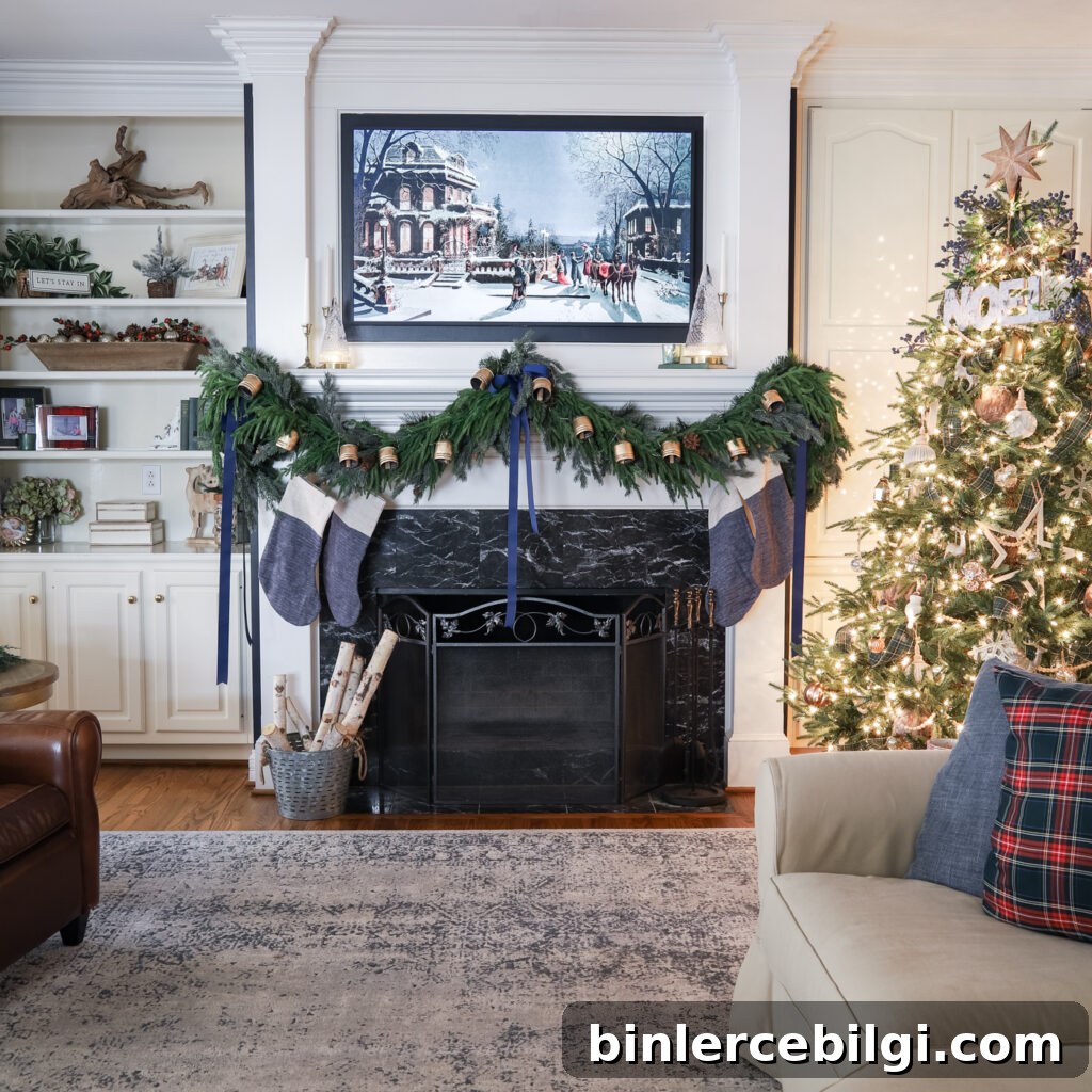 Mantel draped in holiday greenery garland with Christmas bell decoration added on