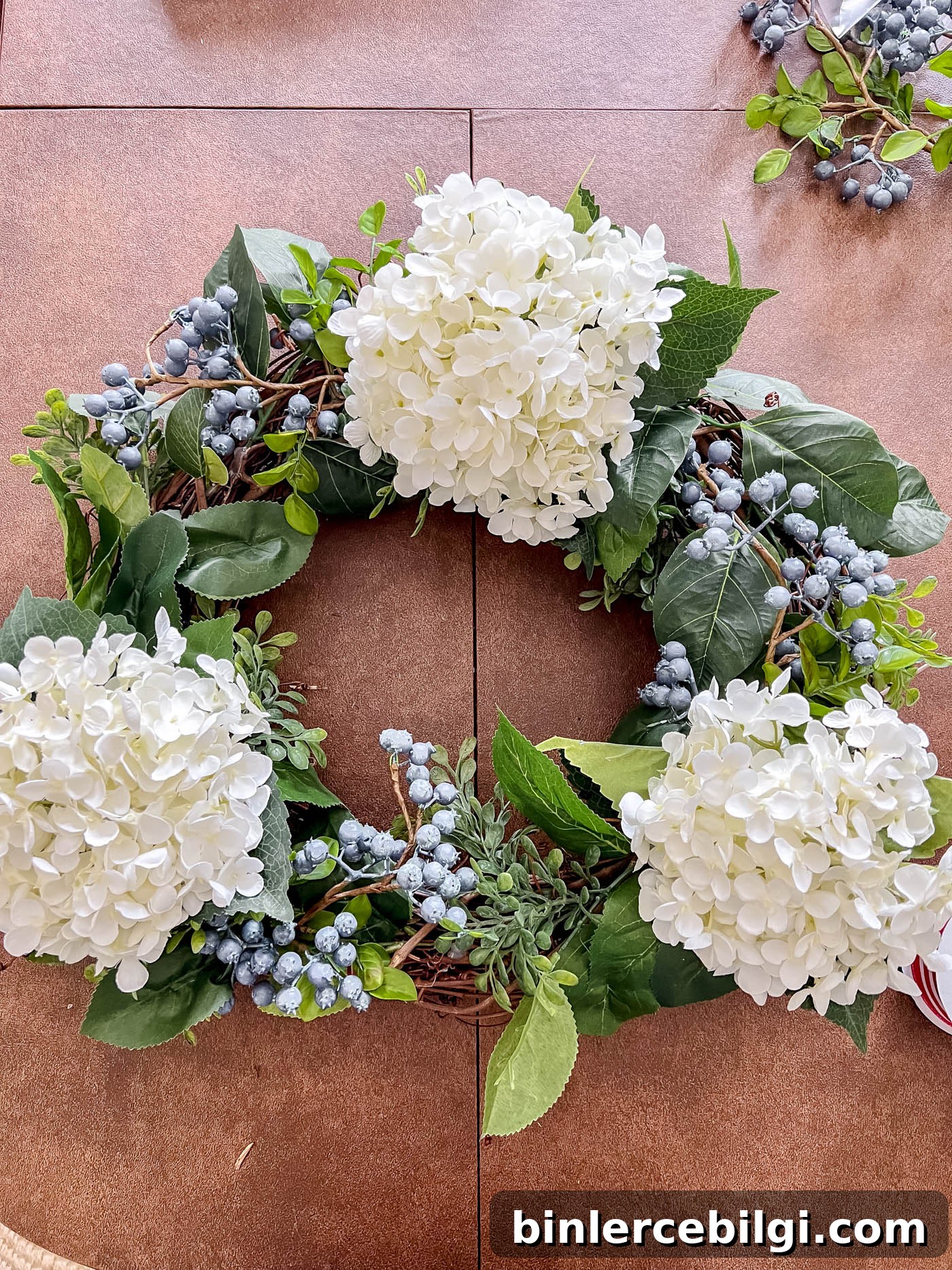 Add blueberry stems to patriotic wreath