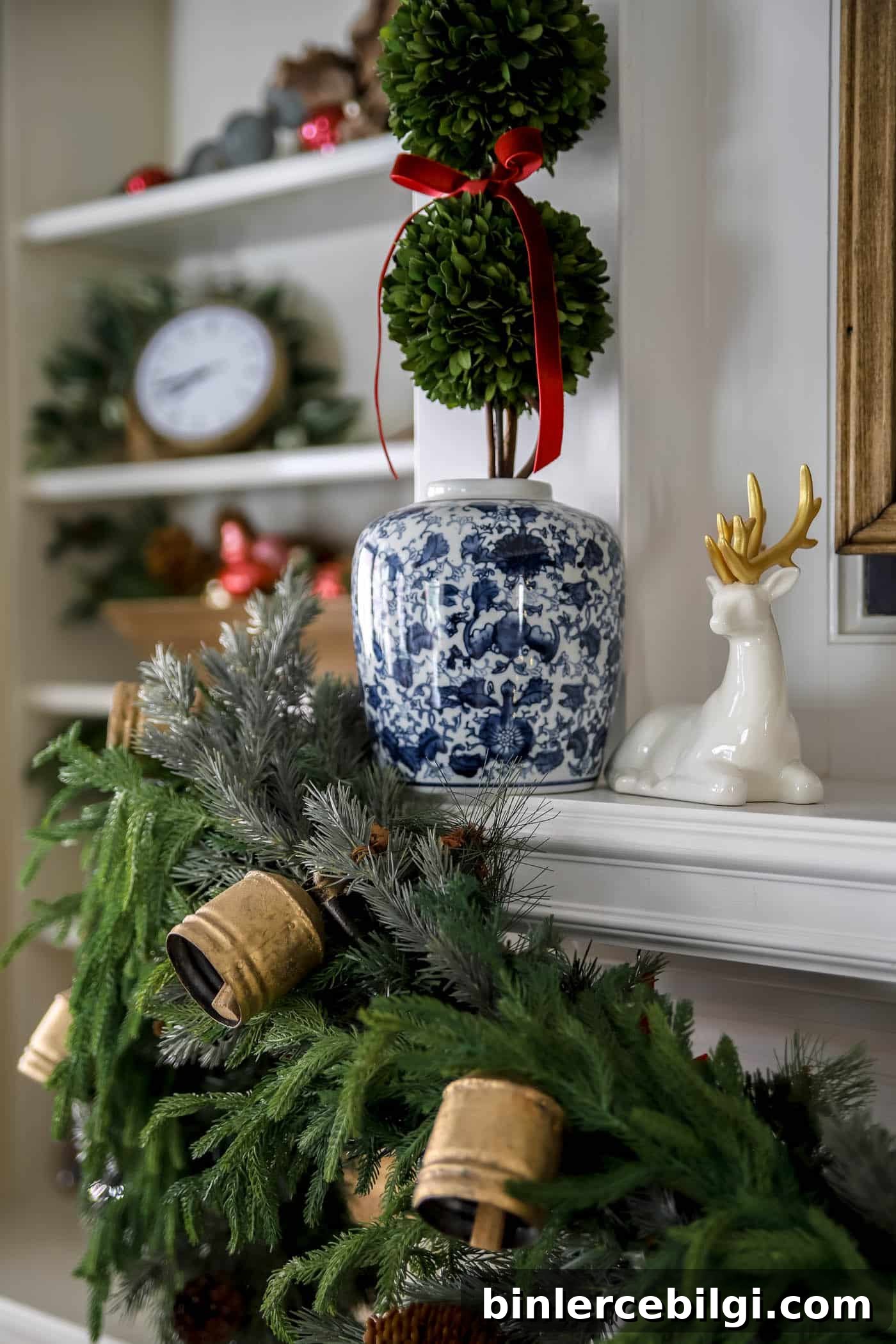 holiday mantel decor with ceramic deer and ginger jar with boxwood topiary and red ribbon