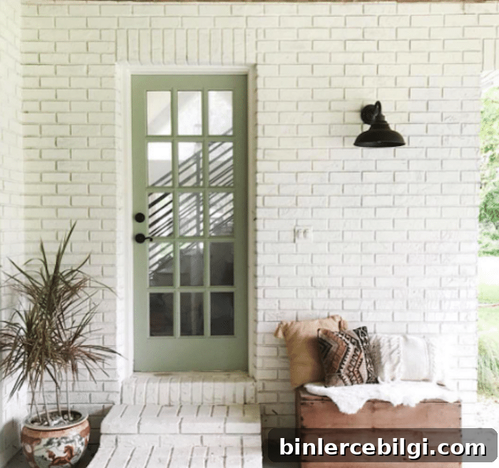 white brick exterior with Sherwin Williams Clary Sage painted door.
