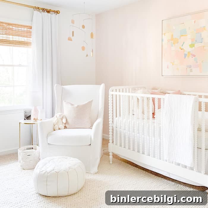 Girl's nursery with an accent wall of Schumacher Raindots Polka Dots wallpaper in Washed Pink.