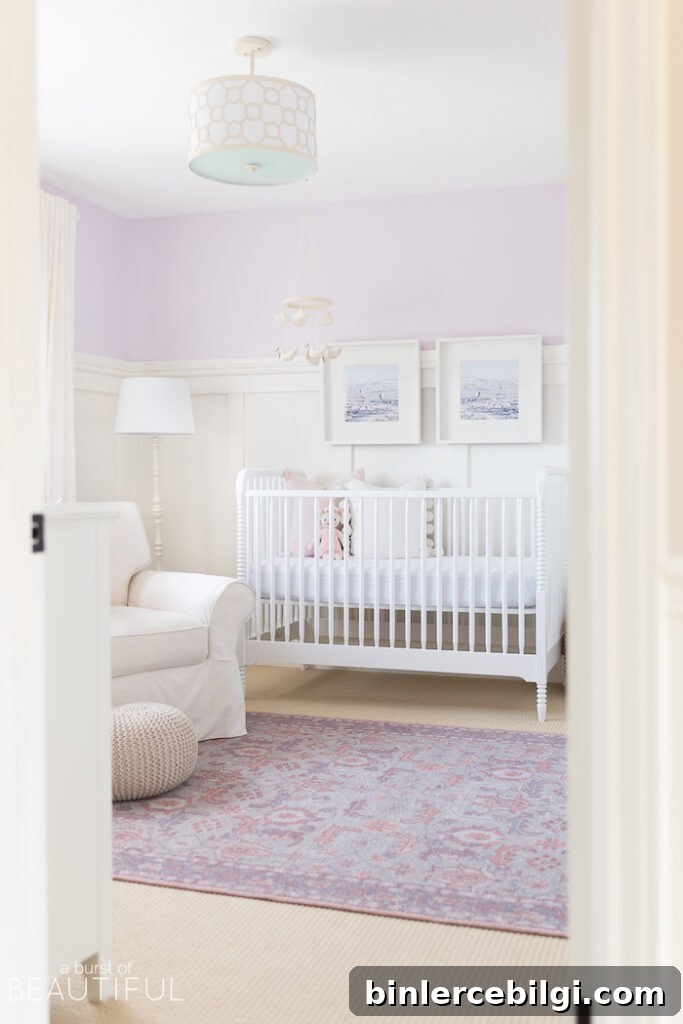 purple wall color in nursery with white crib and white arm chair.