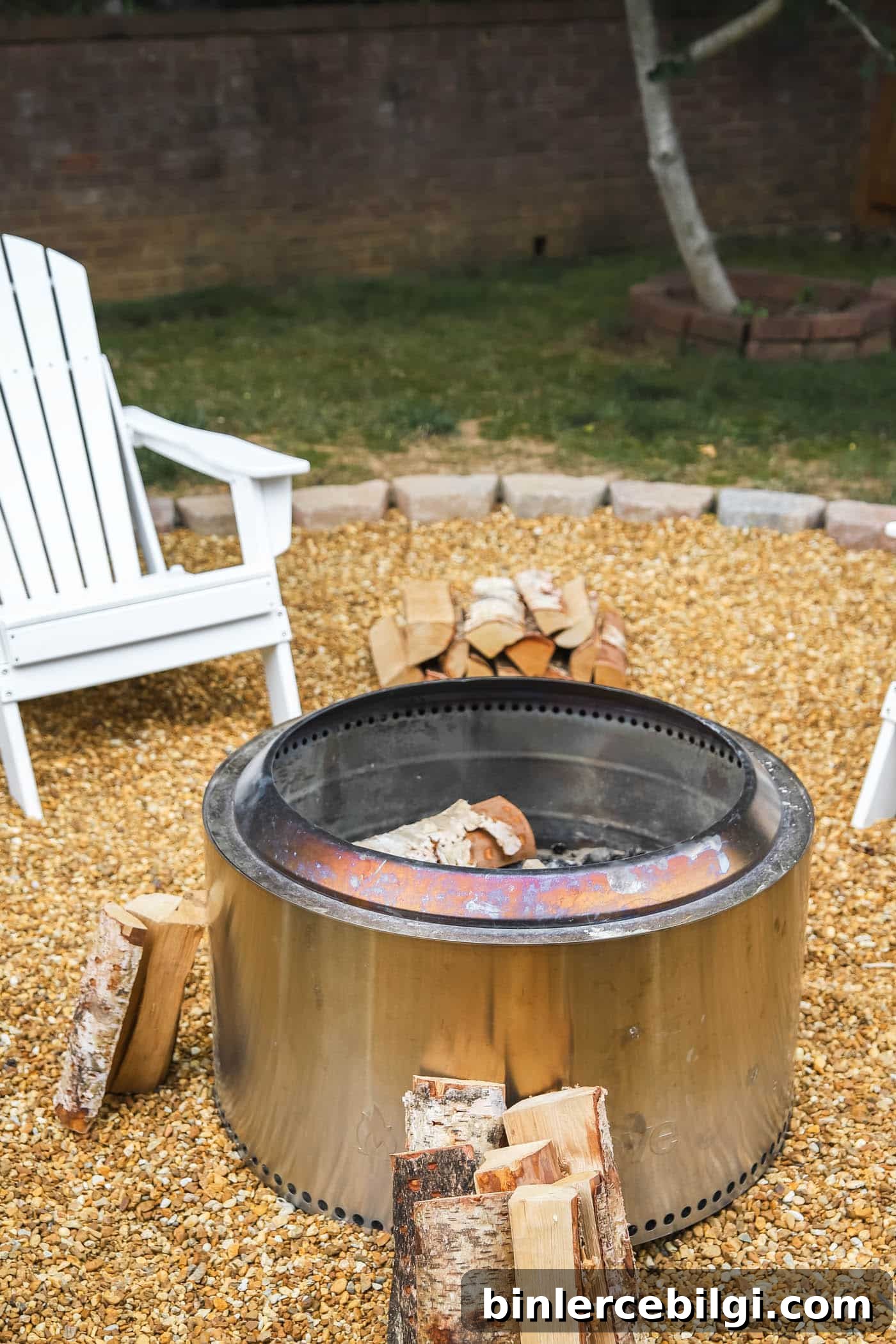Yukon Solo Stove with fire wood on a pea gravel fire pit.