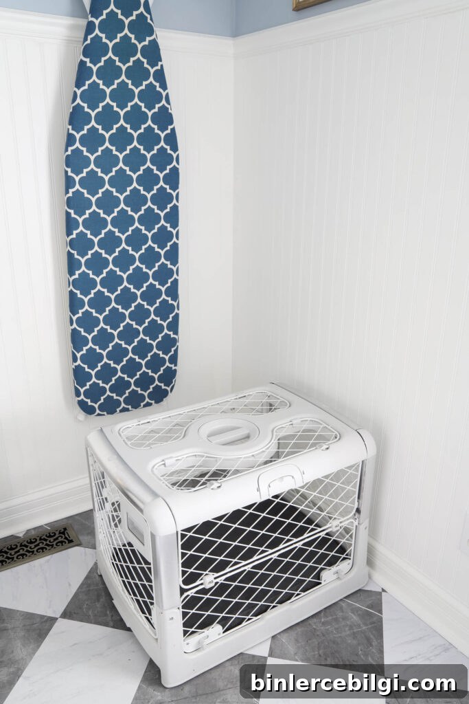 Revol Diggs dog crate in white with a gray pad cover in a laundry room.