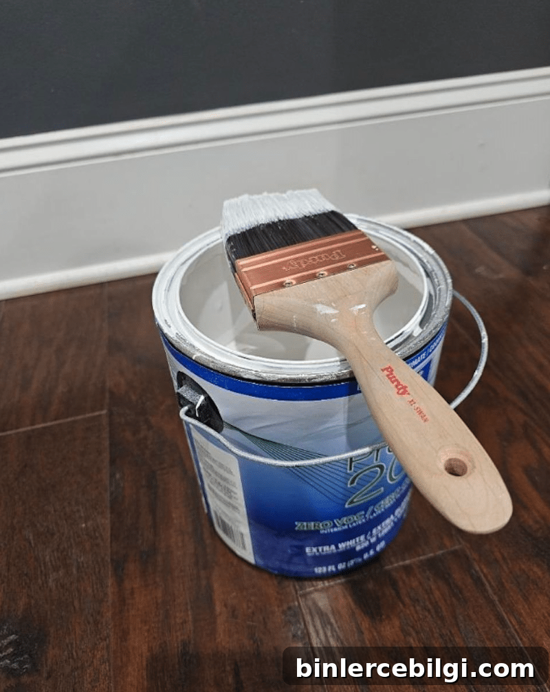 Paintbrush resting on an open can of white paint
