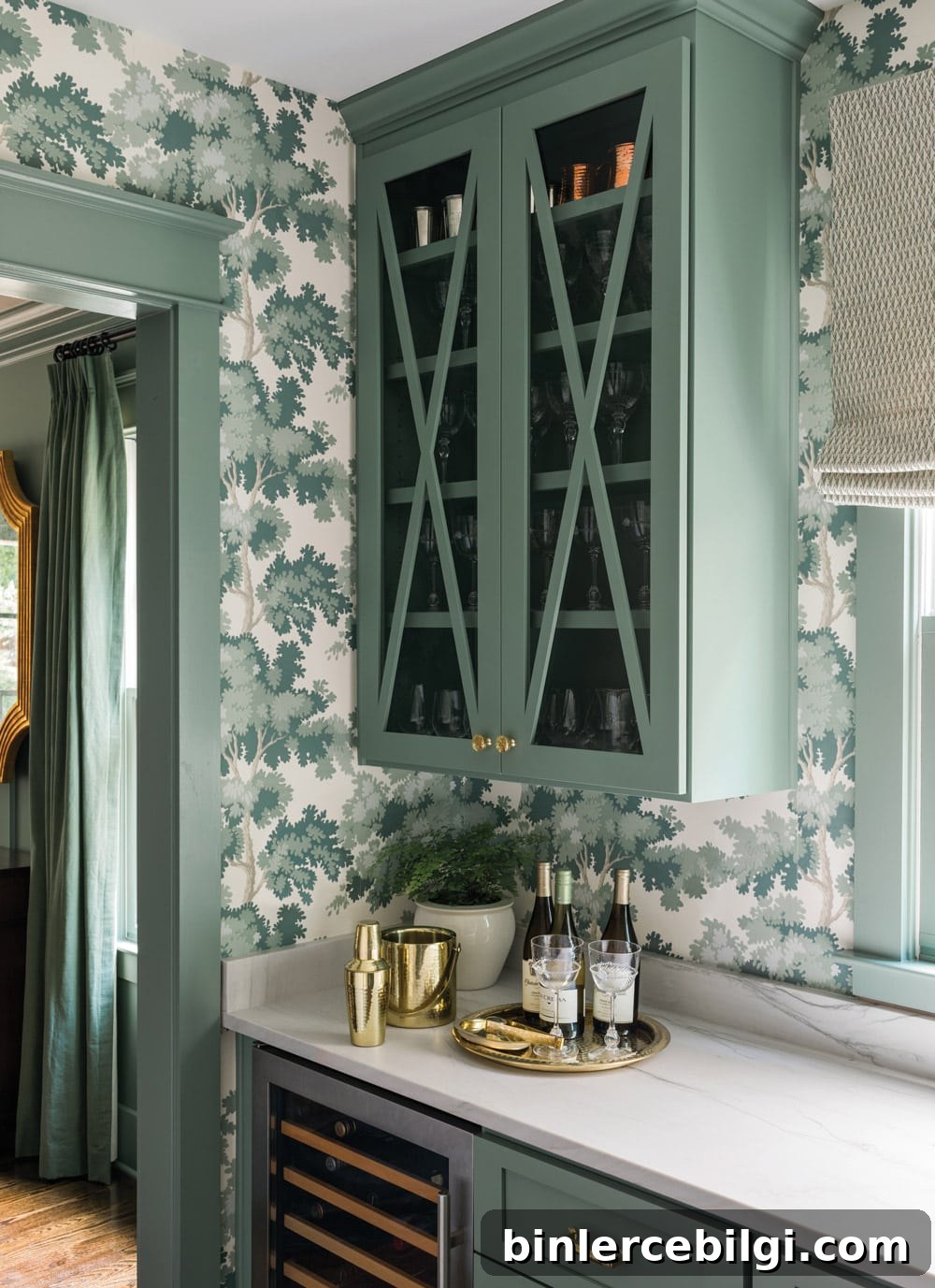 Dark green cabinetry, botanical wallpaper, and marble countertops in a butler's pantry.
