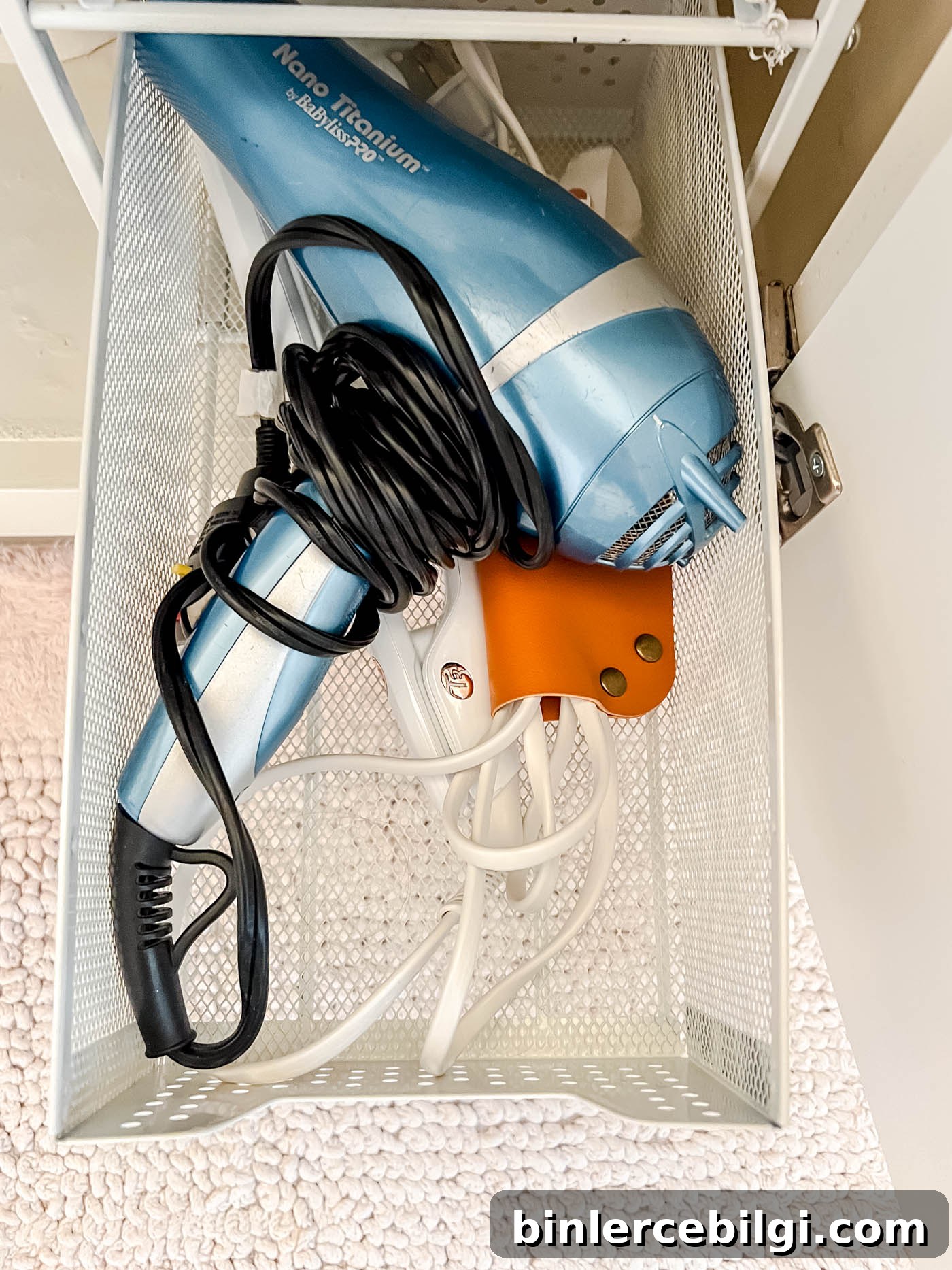 Dryer and straightening irons in the under-the-sink storage.