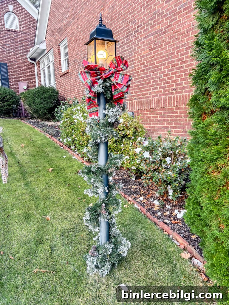 lamppost with holiday garland and red plaid bow.