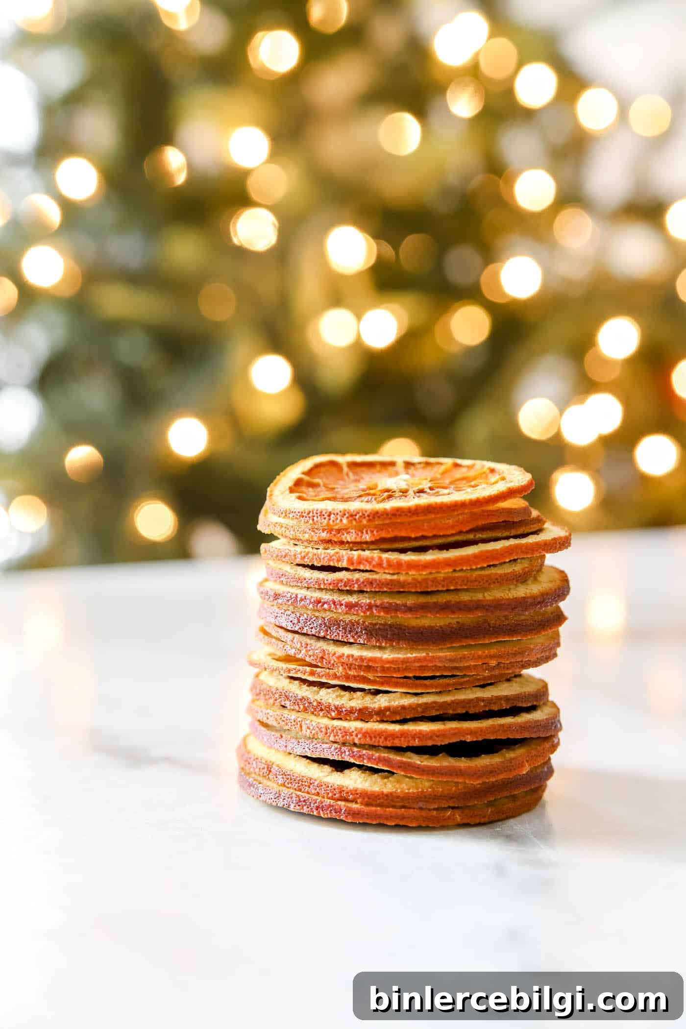 stack of dried orange slices in front of a Christmas tree.