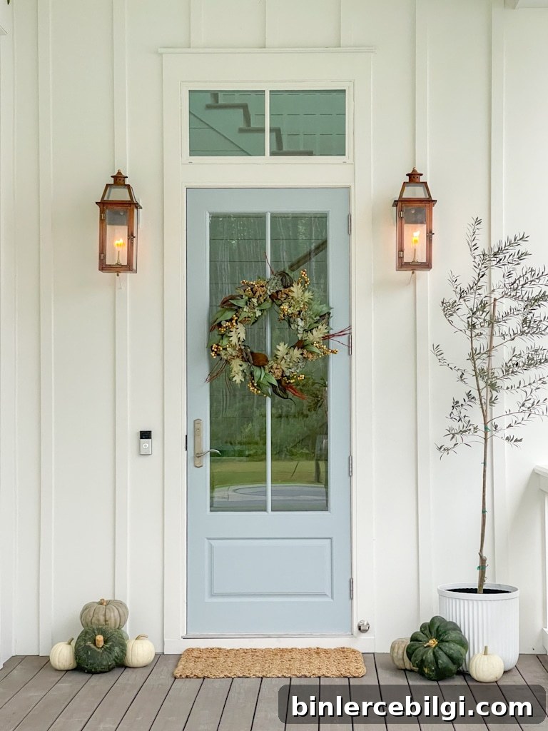 copper lanterns flank front door on coastal fall porch