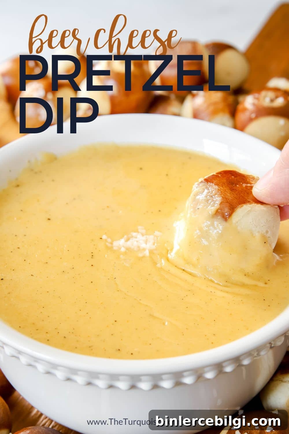 Beer cheese dip with a hand dipping a pretzel into it