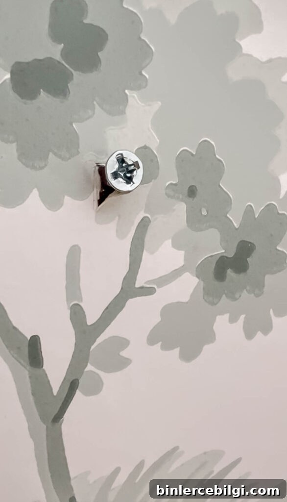 cut a piece of wallpaper before screwing or nailing holes in the wall.