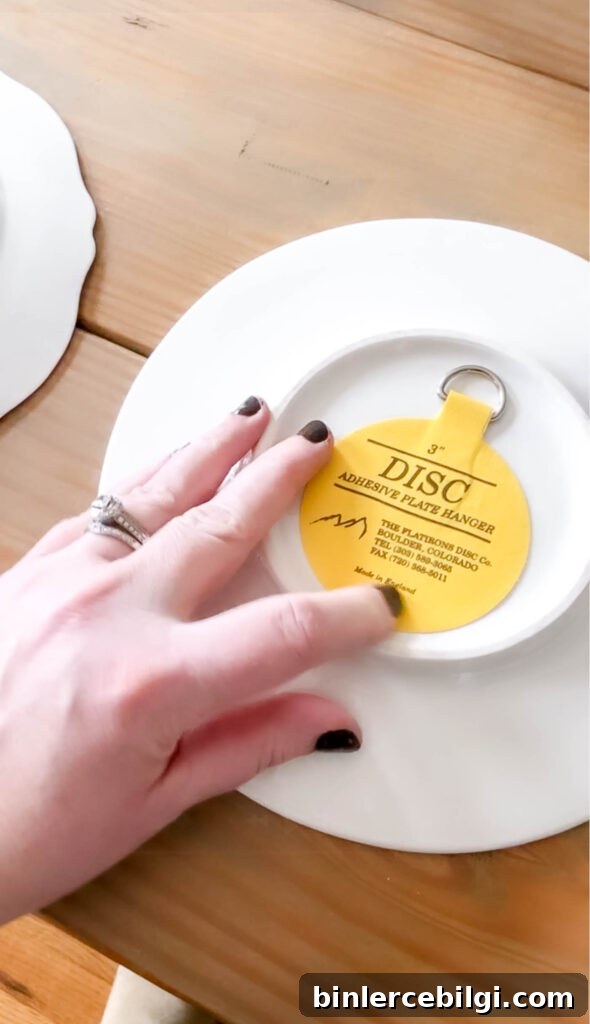 press on the back of the adhesive plate hanger to make sure it's well adhered.