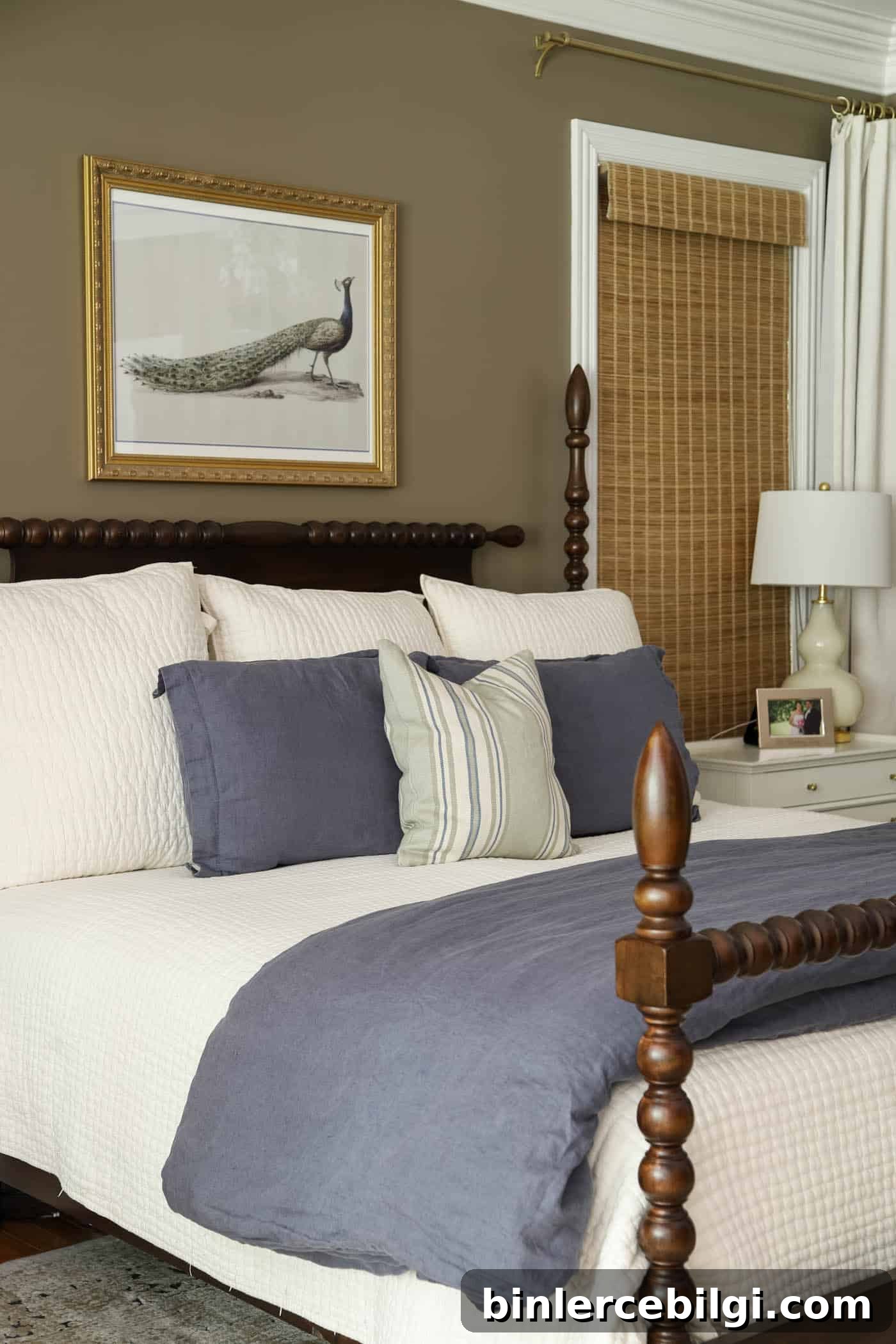 Davenport Tan wall color in a primary bedroom with an ivory quilt and blue bedding.
