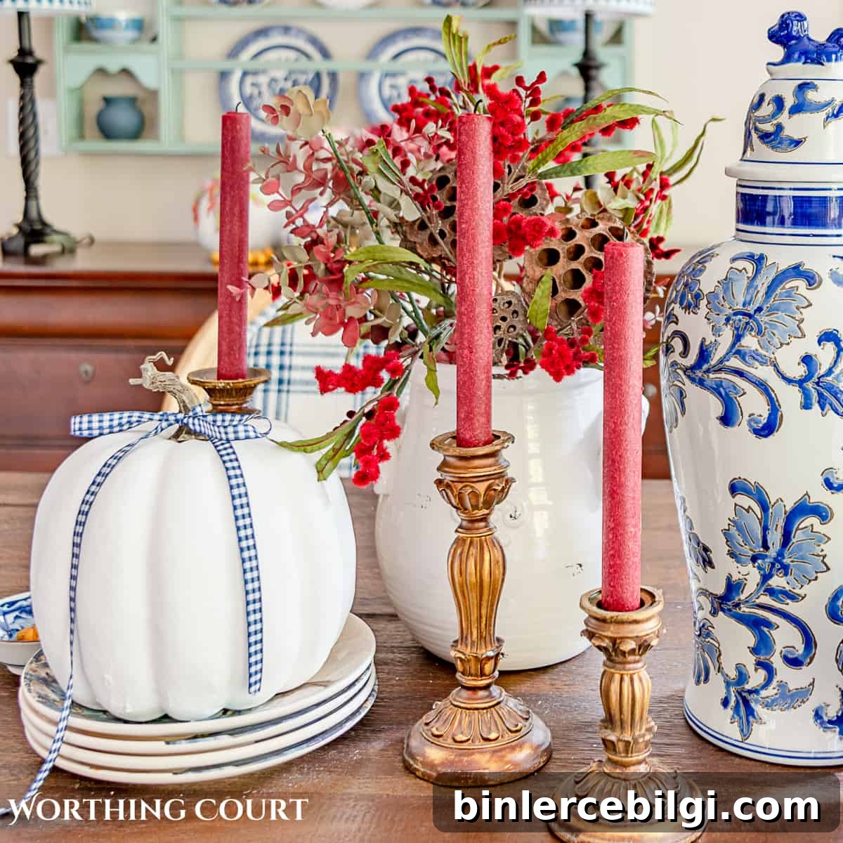 white pumpkin with red candles with wood candlesticks.