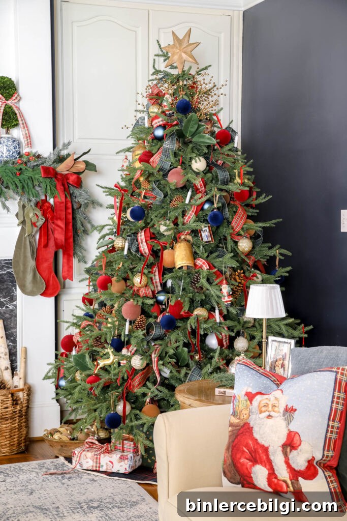 side table with Santa and children in a frame, small cordless lamp and ornament candle with a christmas coffee table book and greenery.