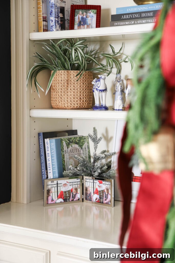 Christmas family photo with Santa in silver frame in a bookshelf decorated for Christmas.