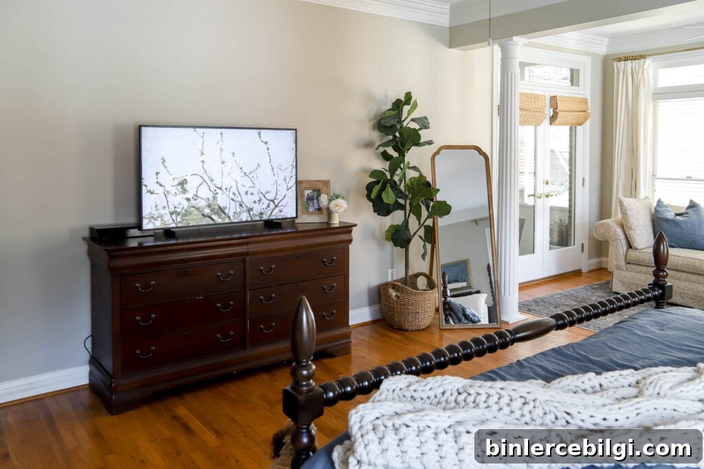 bedroom corner with smaller mirror and large fiddle leaf fig tree.