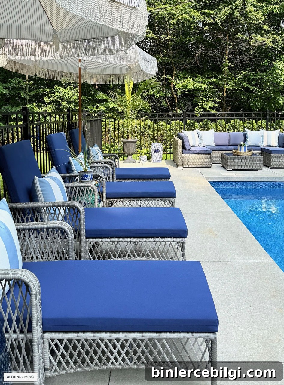 Backyard pool patio ideas with blue lounge chairs, wicker outdoor sectional and navy outdoor decor