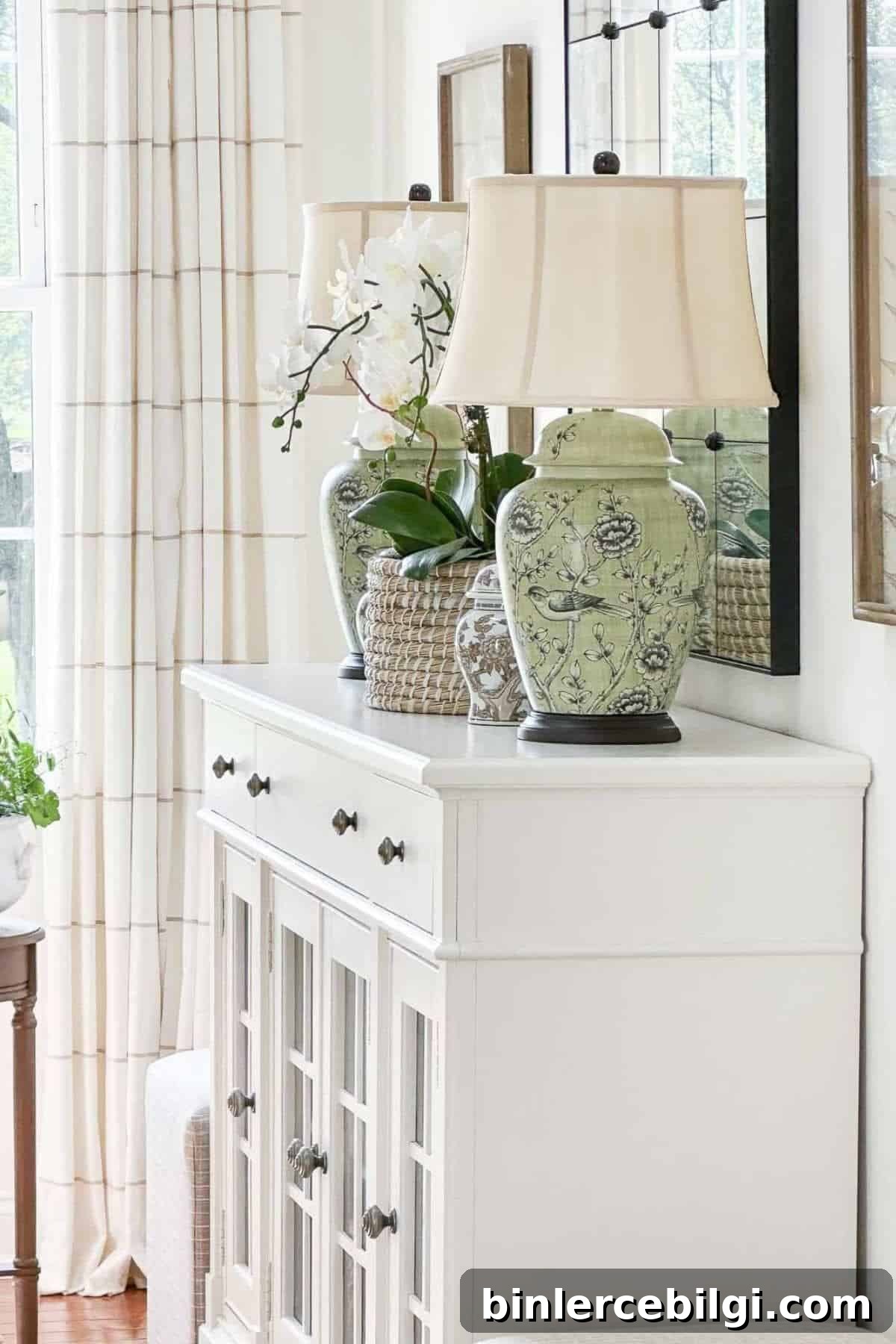white dresser with chinoiserie lamps on top.