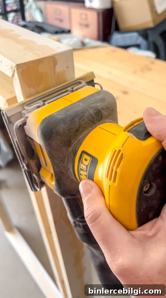 sanding the wood filler on a DIY frame