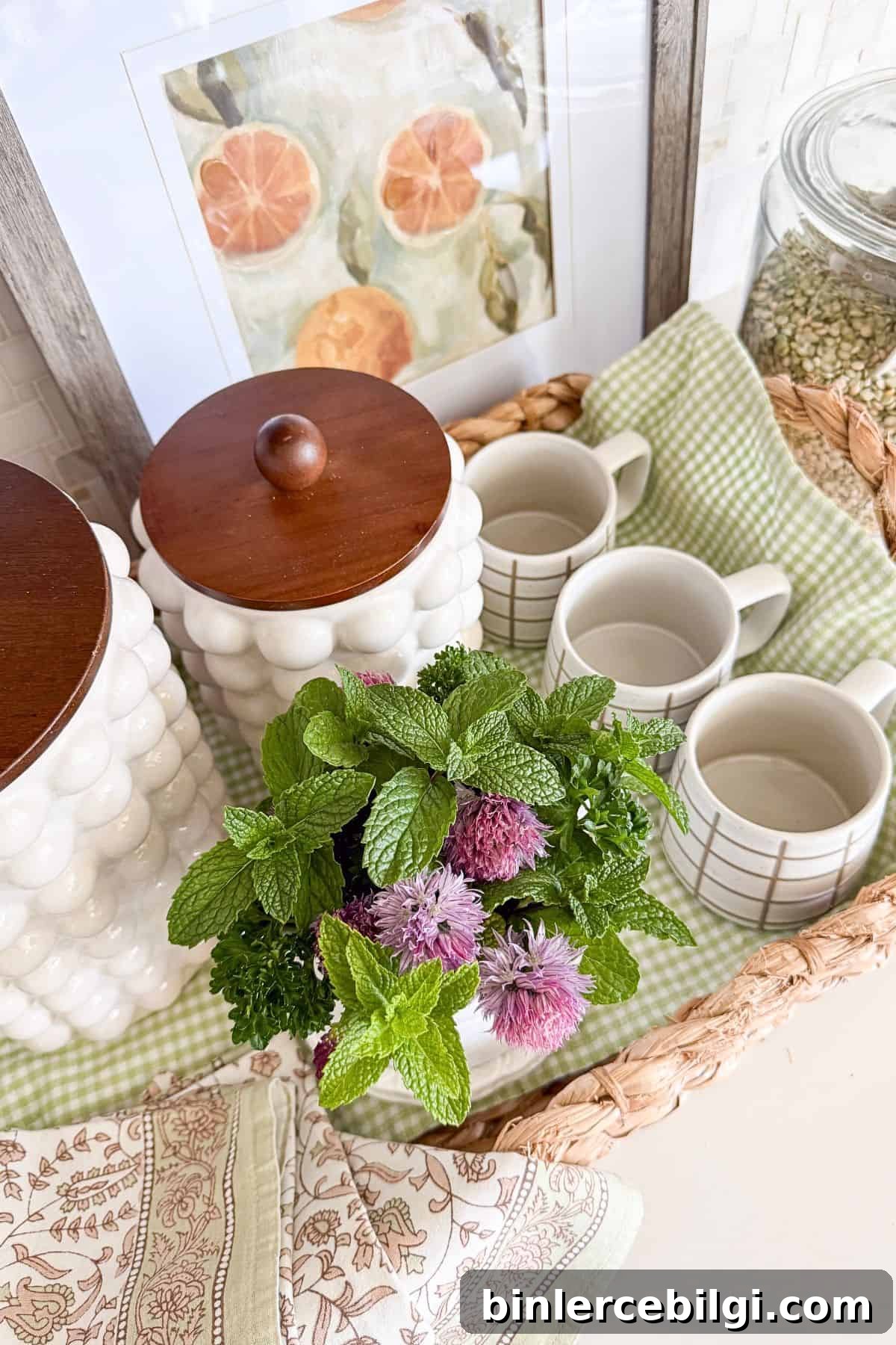summer coffee bar vignette with green check runner, chive herbs, blossoms, mugs and baskets.